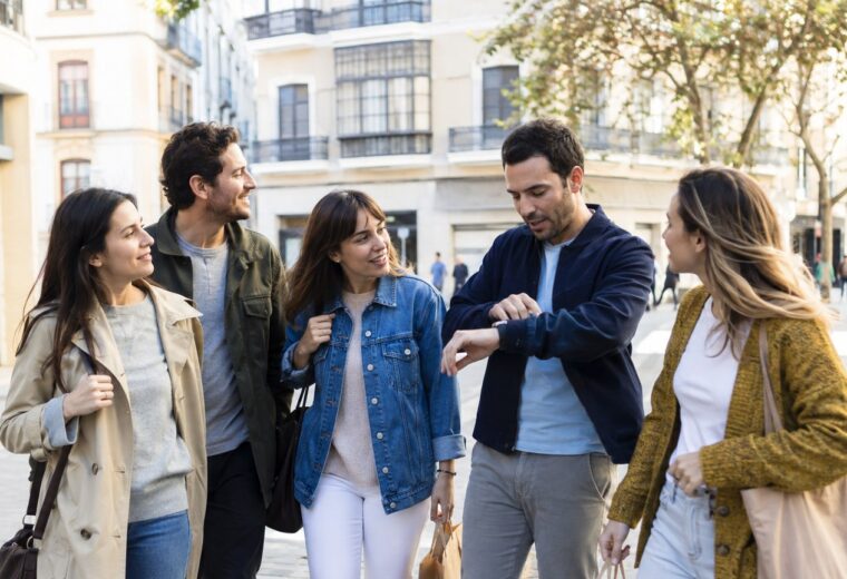 Cinco amigos pasean por una plaza durante una despedida de día