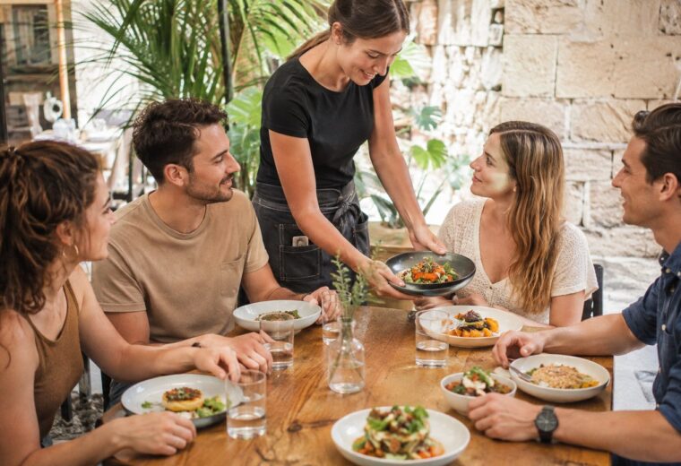 Un grupo de amigos recibe platos diferentes en una comida compartida